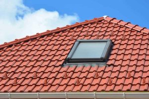 A close-up of a red clay tile roof with a skylight.